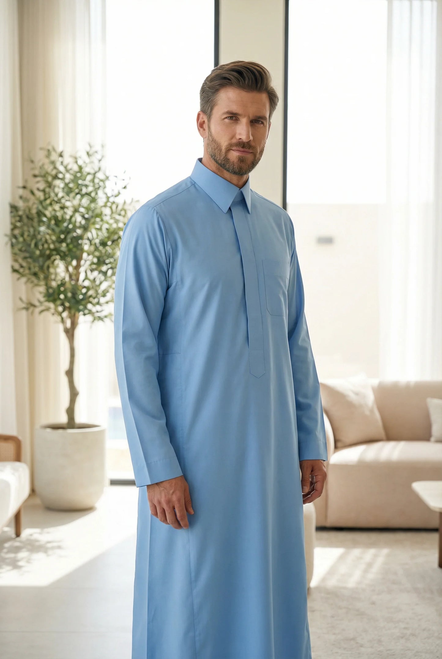 Sky Blue Classic Thobe Clean Everyday Silhouette styled in a bright luxury interior setting, showcasing premium Islamic menswear with contemporary tailoring and timeless Arab elegance. Luxury Saudi thobe, men's designer thobe, premium jubba, ثوب سعودي فاخر للرجال, ثوب أزرق سماوي, ثوب رجالي أنيق, جلابية رجالية فخمة, دشداشة رجالية راقية, ملابس إسلامية رجالية, ثوب يومي فاخر, modest fashion for professionals seeking comfort, sophistication, and elegance throughout Ramadan, Eid, formal gatherings, and upscale ev