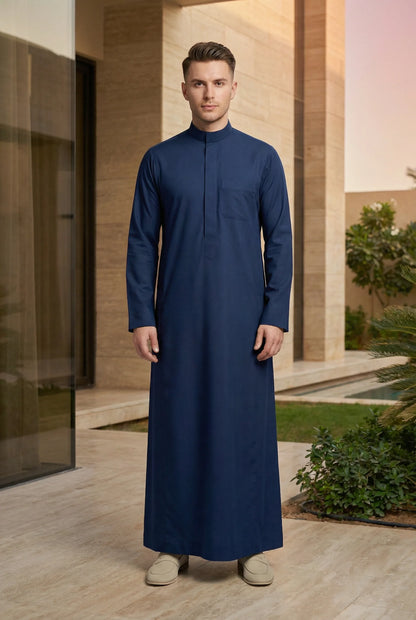 Slate Blue Classic Thobe Calm Refined Everyday Wear styled in a luxury residential setting, showcasing premium Islamic menswear with timeless elegance and modern sophistication. Luxury Saudi thobe, men's designer thobe, premium jubba, ثوب سعودي فاخر للرجال, ثوب أزرق أردوازي, ثوب رجالي أنيق, ثوب كحلي فاخر, جلابية رجالية فخمة, دشداشة رجالية راقية, ملابس إسلامية رجالية, premium modest fashion designed for professionals, Ramadan, Eid, family gatherings, prayer, and elevated everyday living across Saudi Arabia a